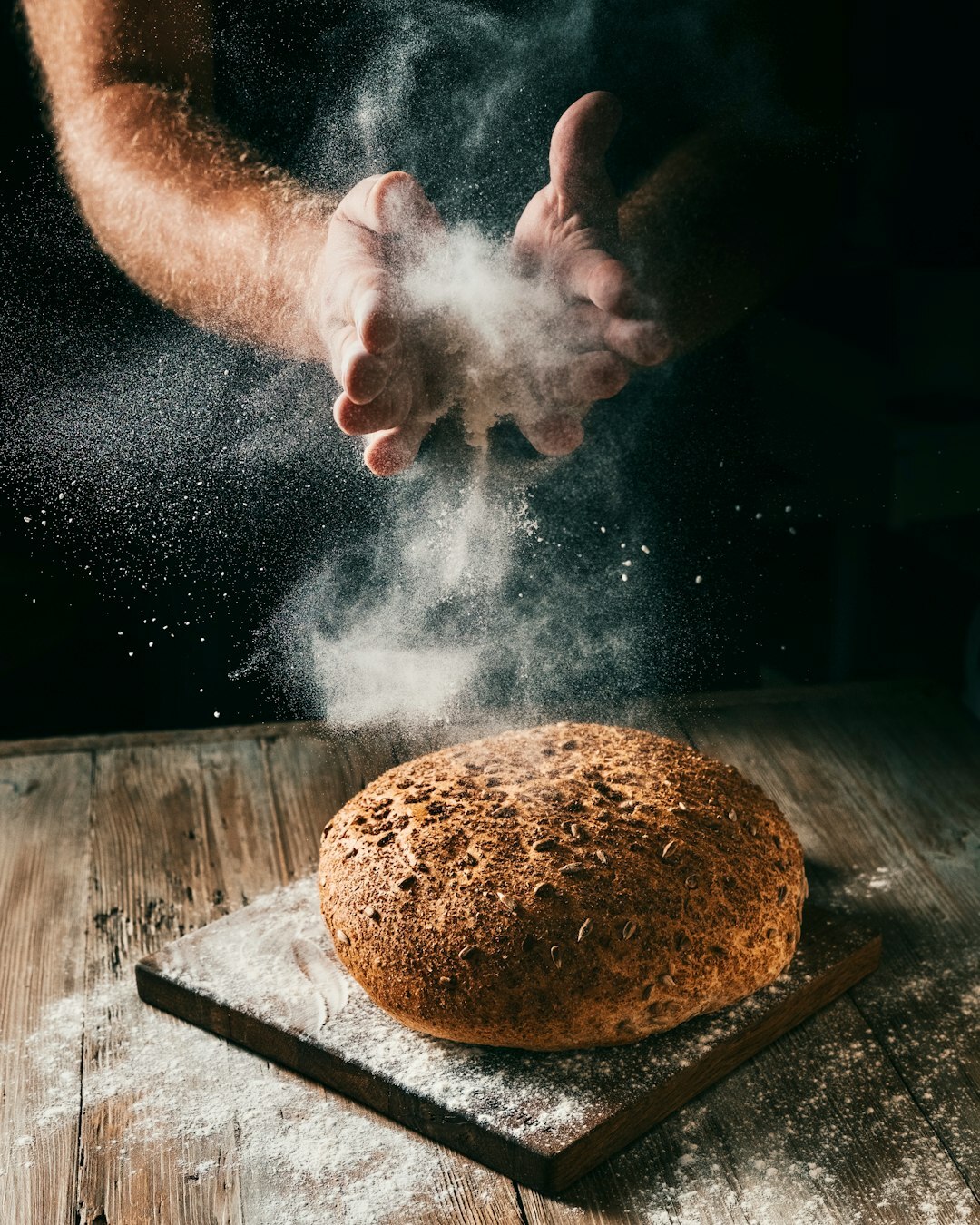Home baker kneading dough on a flour dusted wooden countertop