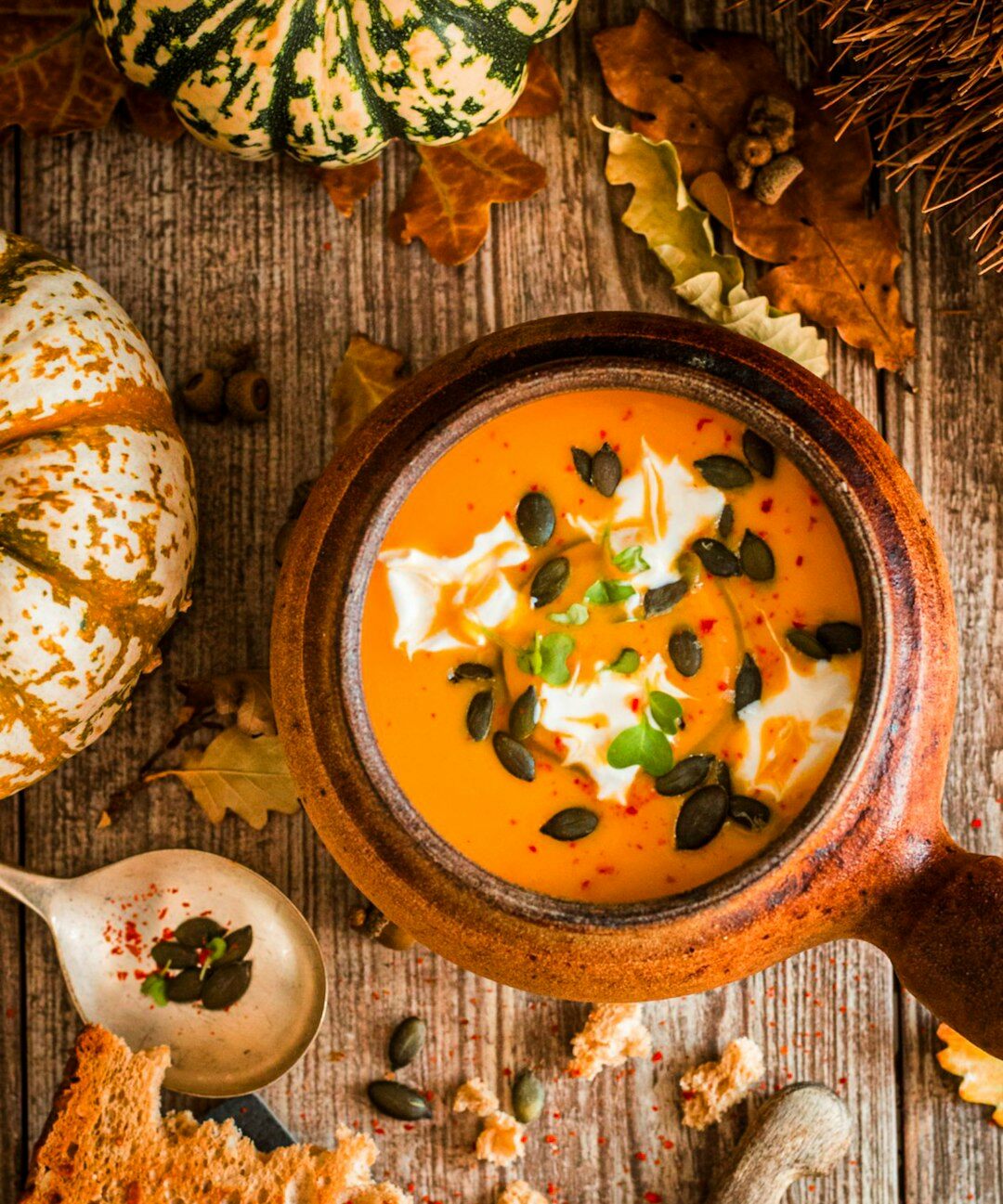 Bowl of warm pumpkin soup with autumn decoration